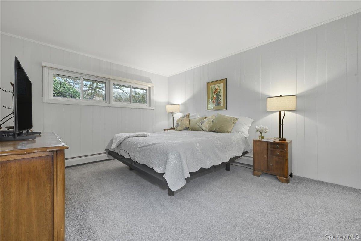 16 Ridge Drive East Roslyn, NY 11576 - Photo 25 of 40 a bedroom with a bed and a flat screen tv