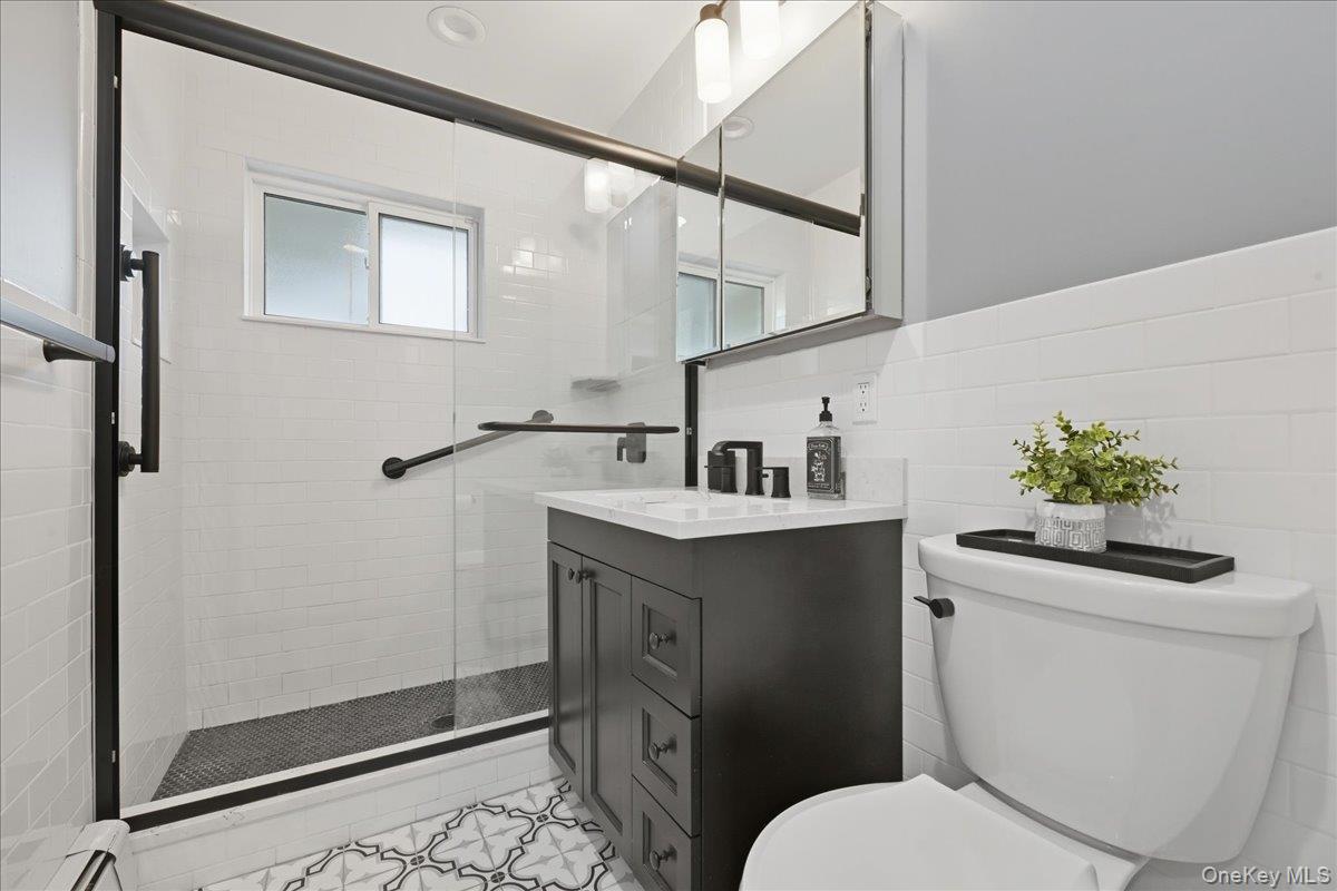 16 Ridge Drive East Roslyn, NY 11576 - Photo 27 of 40 a bathroom with a toilet sink and mirror