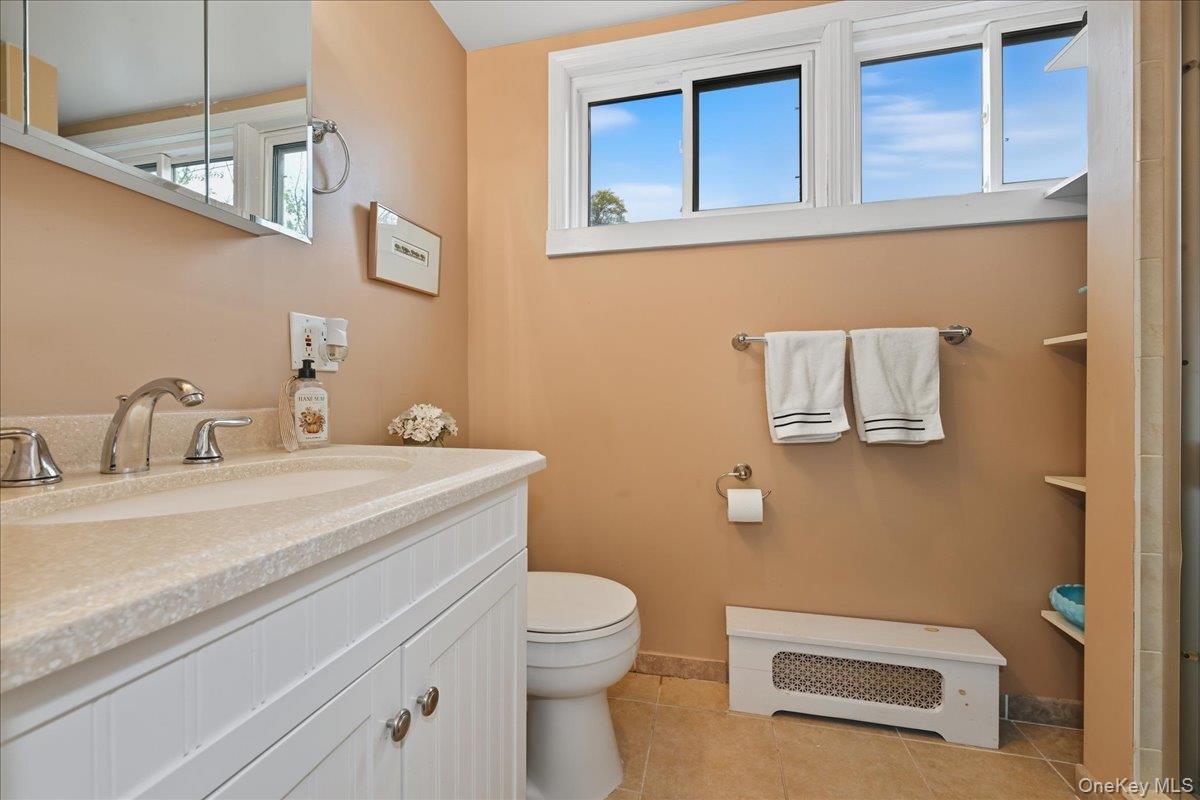 16 Ridge Drive East Roslyn, NY 11576 - Photo 30 of 40 a bathroom with a granite countertop toilet sink and mirror