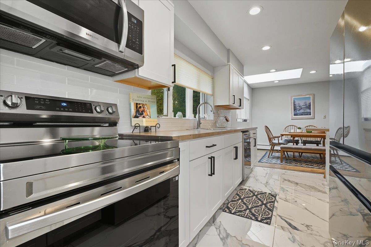 16 Ridge Drive East Roslyn, NY 11576 - Photo 5 of 40 a kitchen with stainless steel appliances kitchen island granite countertop a stove and a sink