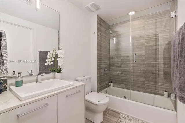 a bathroom with a sink a toilet and shower