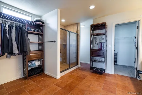 a view of walk in closet with clothes and shoes