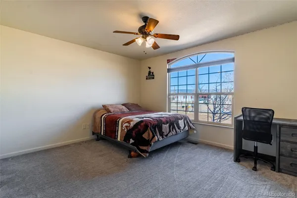 a spacious bedroom with a bed and a chandelier