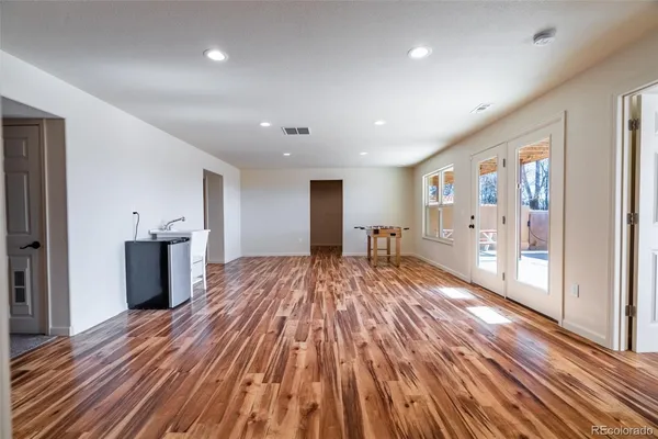 a view of empty room with wooden floor and windows