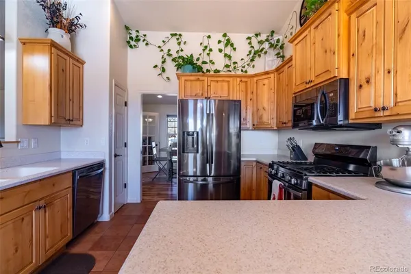 a kitchen with stainless steel appliances granite countertop a refrigerator a stove top oven a sink and dishwasher