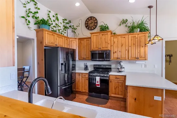a kitchen with stainless steel appliances a stove refrigerator sink and microwave