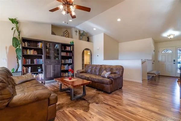 a living room with furniture and a book shelf