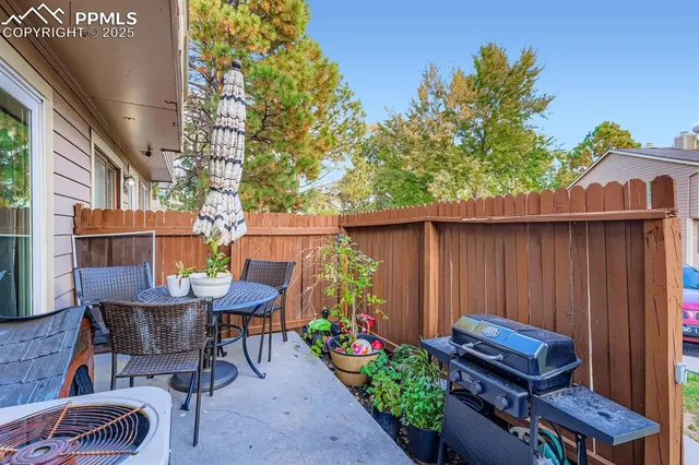 a backyard of a house with barbeque oven table and chairs