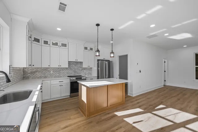 a kitchen with granite countertop cabinets appliances and a counter space
