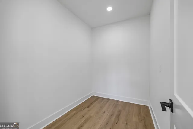a view of empty room with wooden floor and window