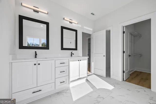 an empty room with wooden floor a ceiling fan and windows