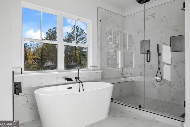 a bedroom with a bed a couch and a flat screen tv