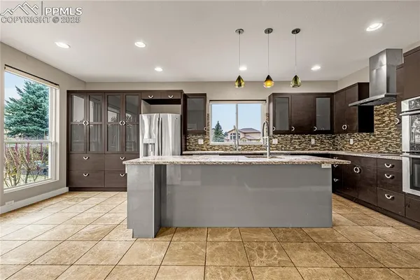 a large kitchen with kitchen island granite countertop a large counter top stainless steel appliances and cabinets