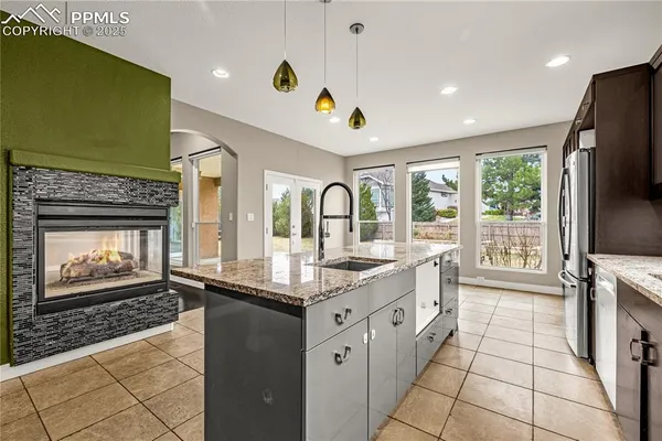 a large kitchen with stainless steel appliances granite countertop a stove a sink and a microwave