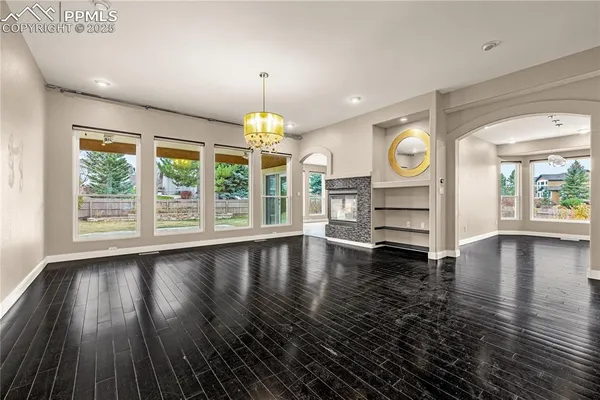 an empty room with wooden floor and window