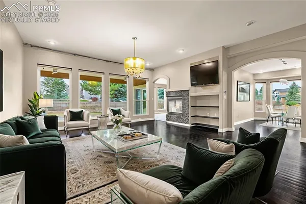 a living room with furniture ceiling fan and a large window