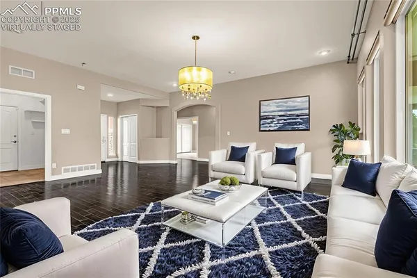 a living room with furniture chandelier and a table