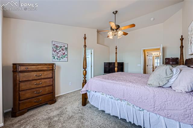 12510 Motley Road Peyton, CO 80831 - Photo 17 of 36 Bedroom with lofted ceiling, carpet, and ceiling fan