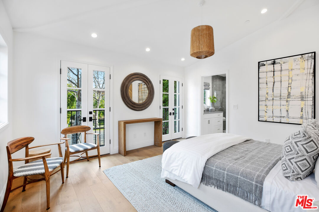 623 Walden Drive Beverly Hills, CA 90210 - Photo 17 of 28 a bedroom with a bed a dresser with chair and mirror