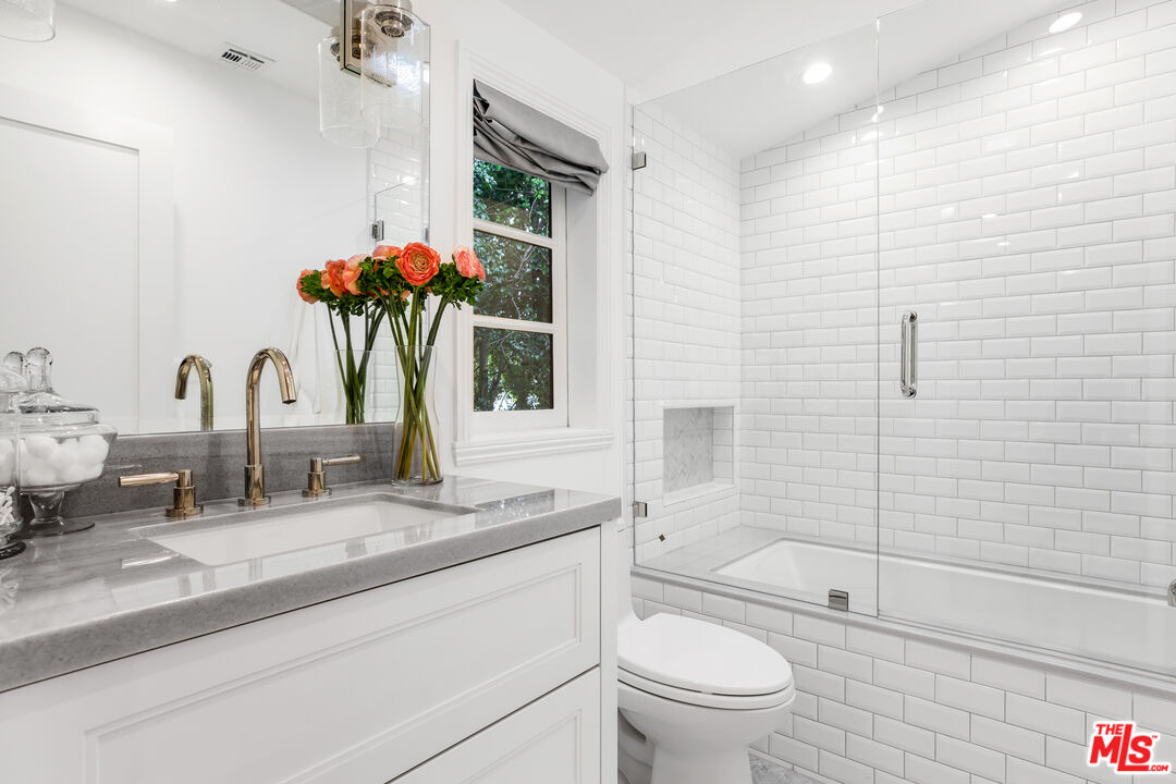 623 Walden Drive Beverly Hills, CA 90210 - Photo 20 of 28 a bathroom with a granite countertop sink a toilet and shower