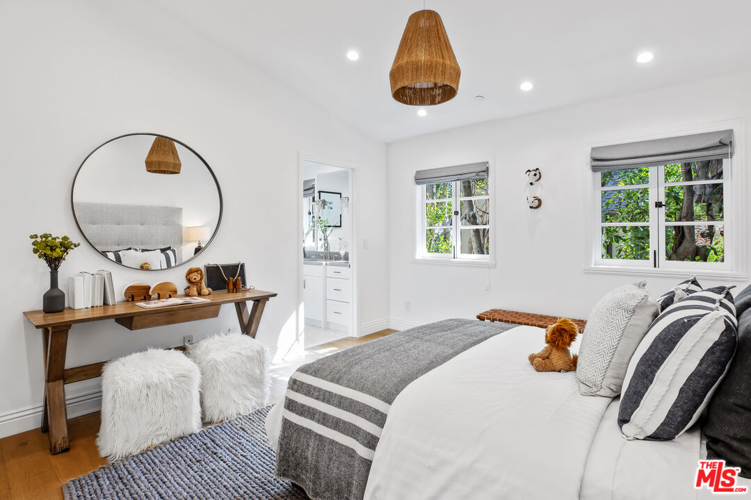 623 Walden Drive Beverly Hills, CA 90210 - Photo 22 of 28 a bedroom with a bed and a chandelier