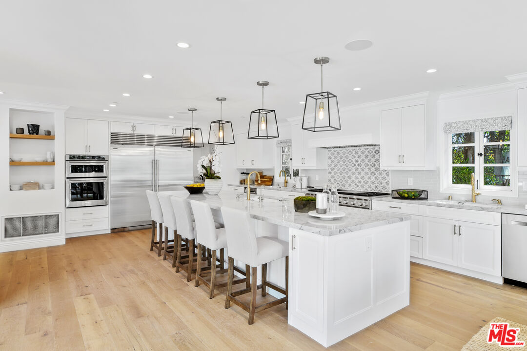 623 Walden Drive Beverly Hills, CA 90210 - Photo 6 of 28 a kitchen with stainless steel appliances white cabinets and wooden floor