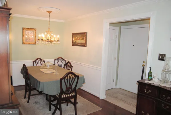 a view of a dining room with furniture wooden floor and a chandelier