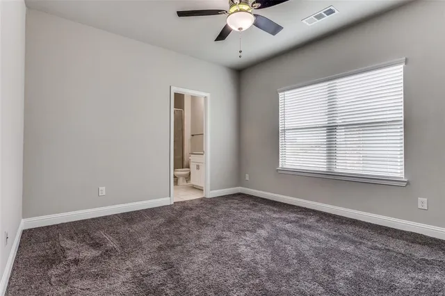 a bathroom with a granite countertop sink a toilet and shower