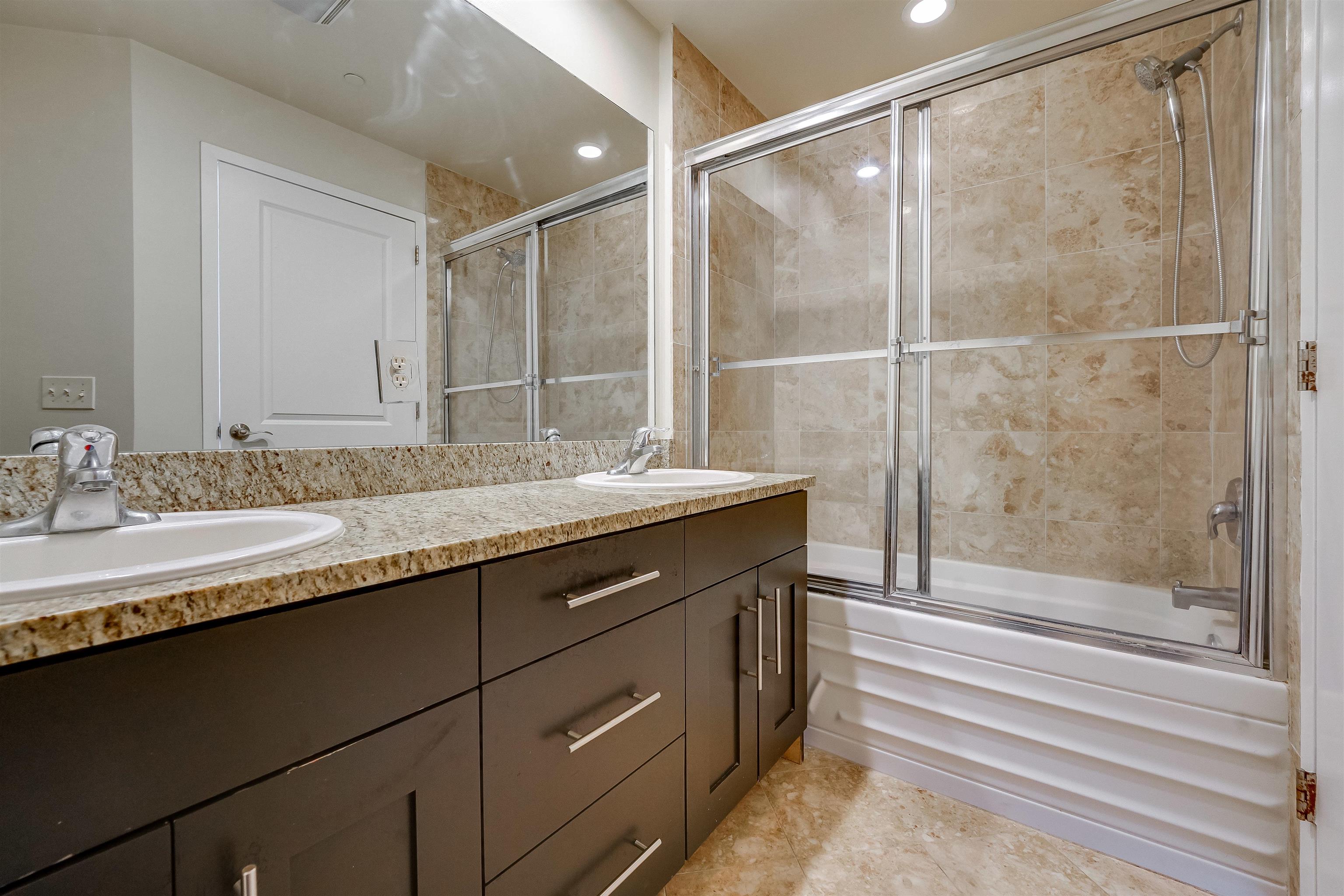 29 1st Street, Unit 401 Hackensack, NJ 07601 - Photo 14 of 23 a bathroom with a granite countertop sink mirror and double