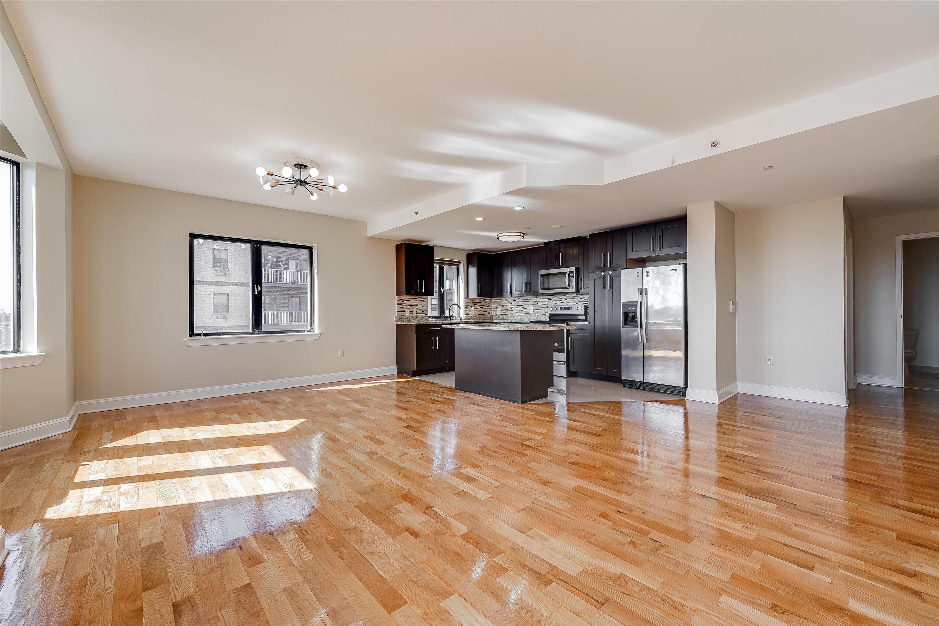 29 1st Street, Unit 401 Hackensack, NJ 07601 - Photo 3 of 23 a view of kitchen and hall with wooden floor