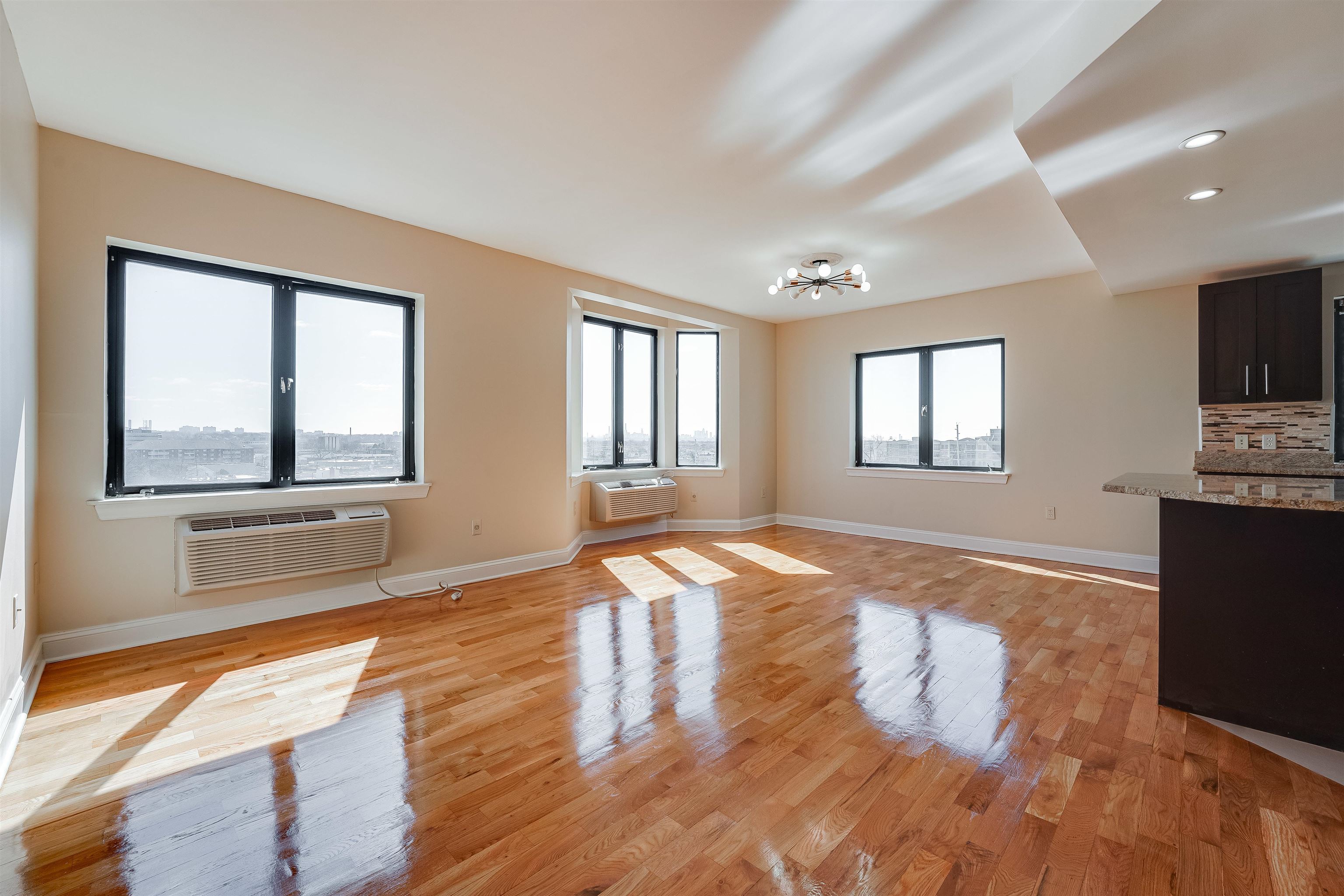 29 1st Street, Unit 401 Hackensack, NJ 07601 - Photo 4 of 23 a view of an empty room with wooden floor and a window