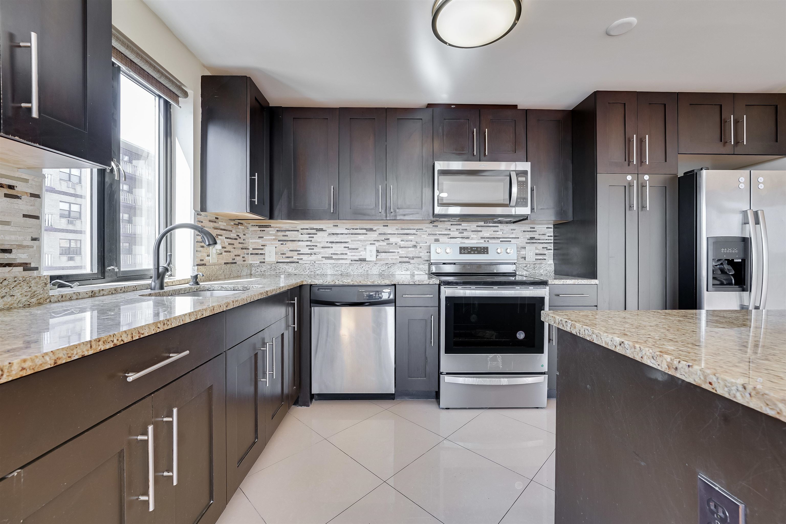 29 1st Street, Unit 401 Hackensack, NJ 07601 - Photo 5 of 23 a kitchen with granite countertop stainless steel appliances and cabinets