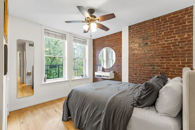 a bedroom with a bed mirror and window