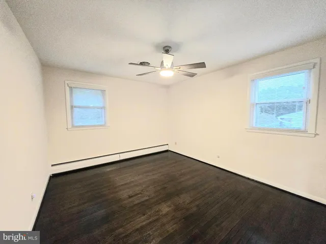 an empty room with wooden floor and window