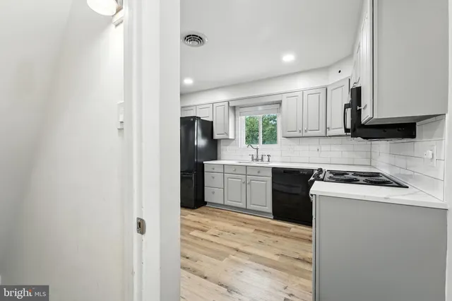 a kitchen with a refrigerator sink and cabinets