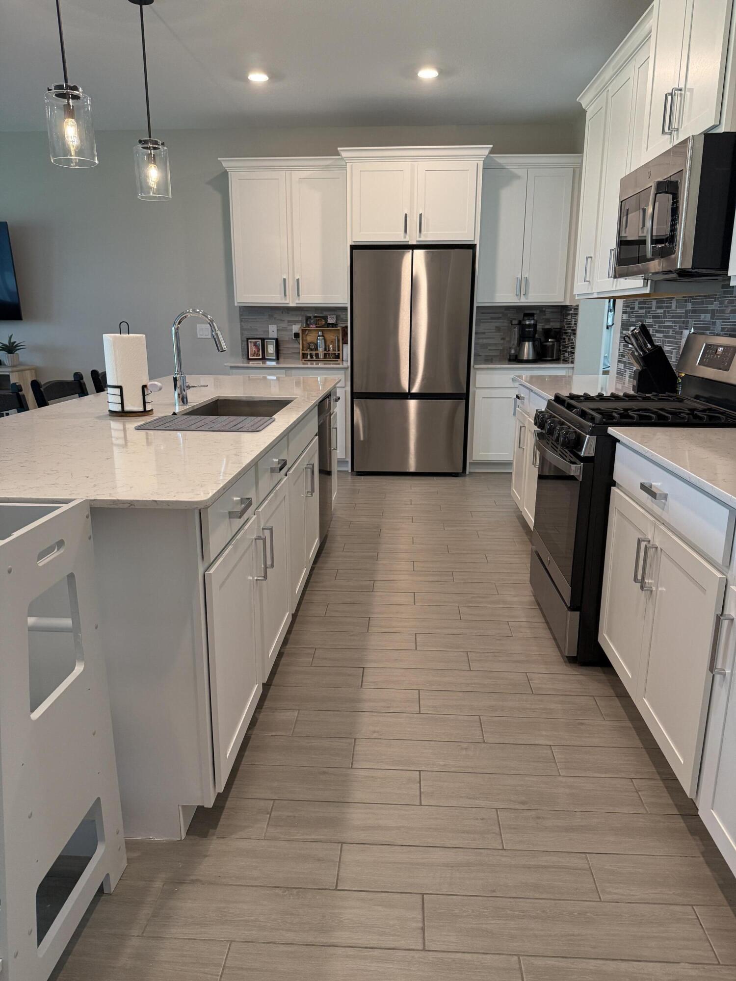 1382 Arrowhead Point Road Loxahatchee, FL 33470 - Photo 14 of 55 a large kitchen with stainless steel appliances granite countertop a refrigerator a stove a sink and a microwave