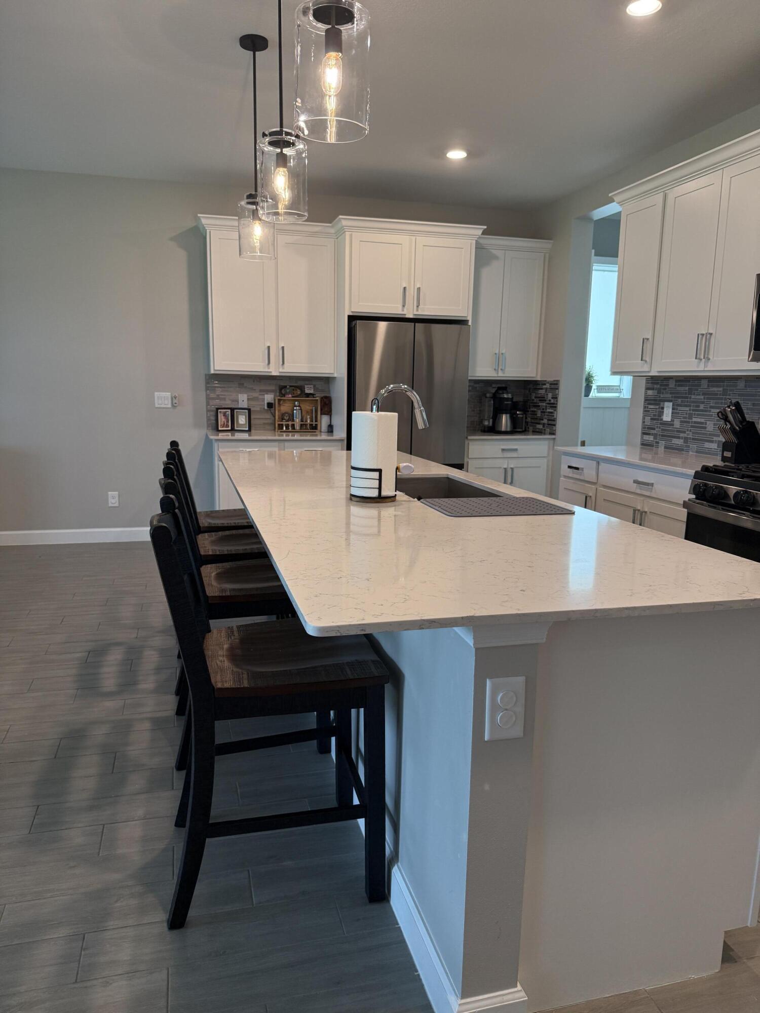 1382 Arrowhead Point Road Loxahatchee, FL 33470 - Photo 16 of 55 a kitchen with a table chairs microwave and cabinets