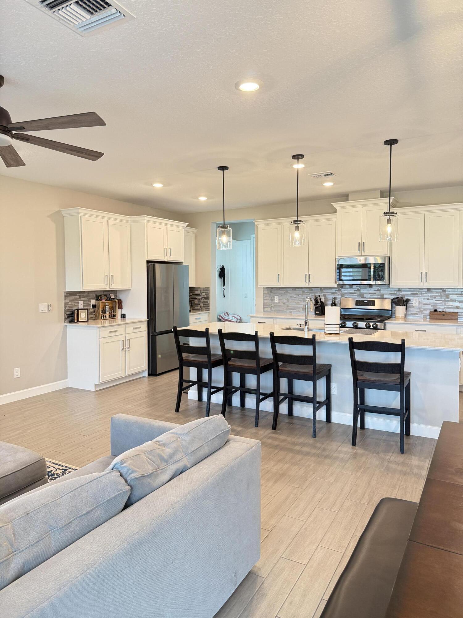 1382 Arrowhead Point Road Loxahatchee, FL 33470 - Photo 19 of 55 a kitchen with stainless steel appliances kitchen island granite top and refrigerator