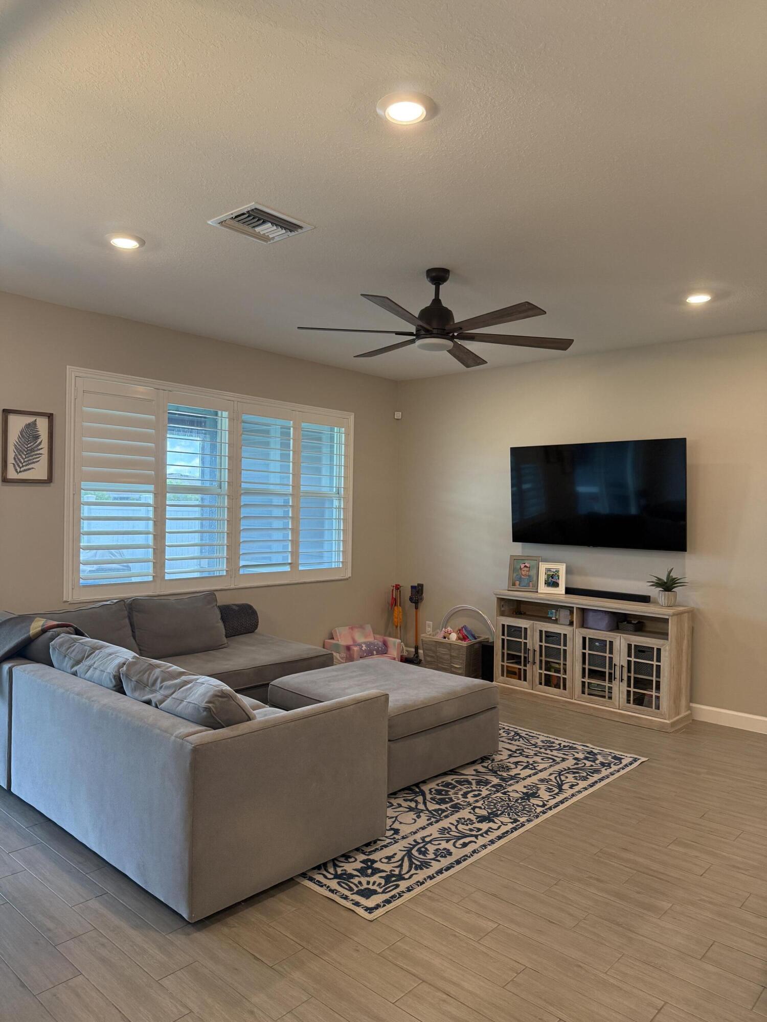 1382 Arrowhead Point Road Loxahatchee, FL 33470 - Photo 22 of 55 a living room with furniture and a flat screen tv