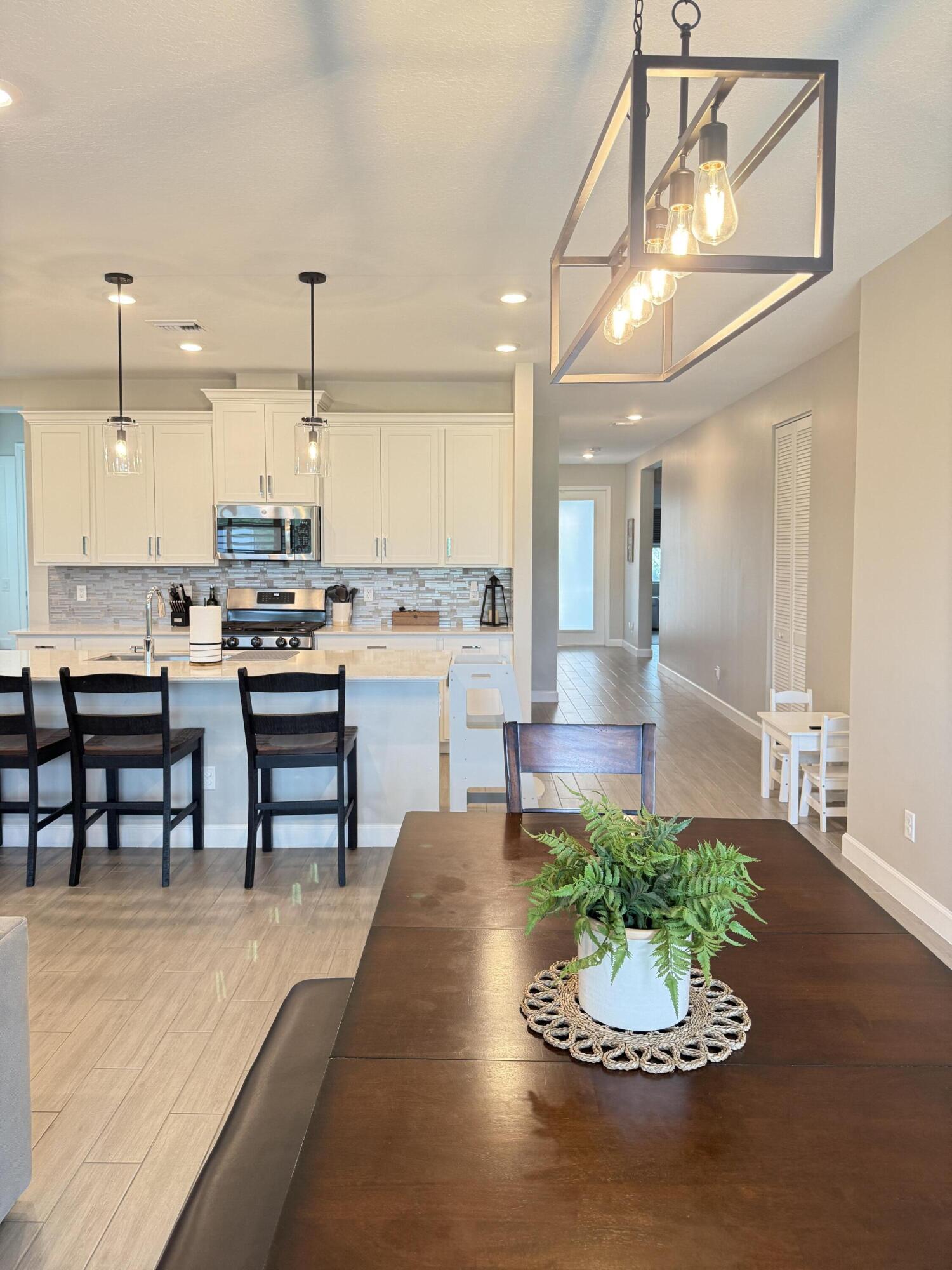 1382 Arrowhead Point Road Loxahatchee, FL 33470 - Photo 24 of 55 a living room with stainless steel appliances kitchen island a table and chairs in it