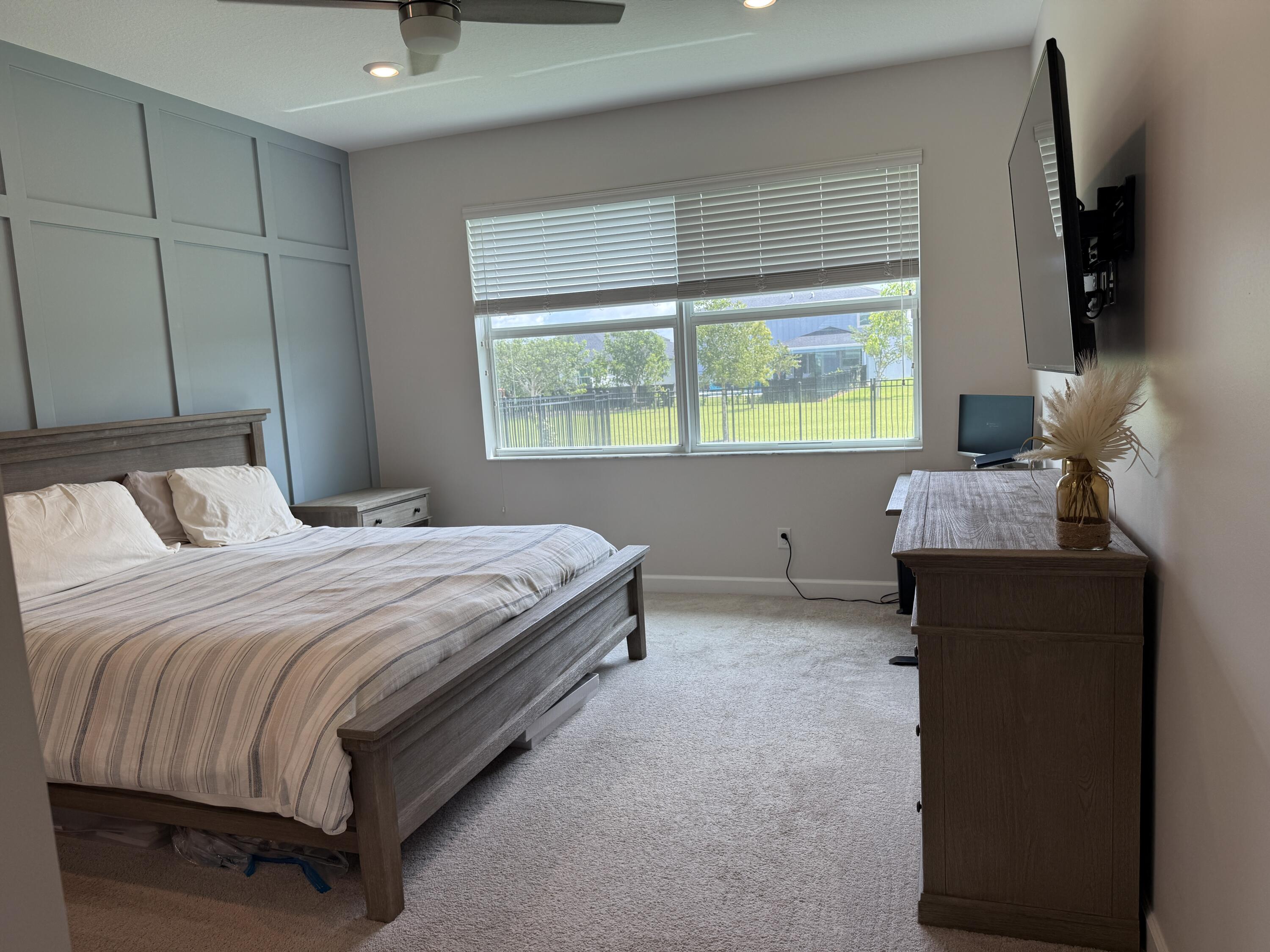 1382 Arrowhead Point Road Loxahatchee, FL 33470 - Photo 31 of 55 a bedroom with a bed and a flat tv screen on dresser