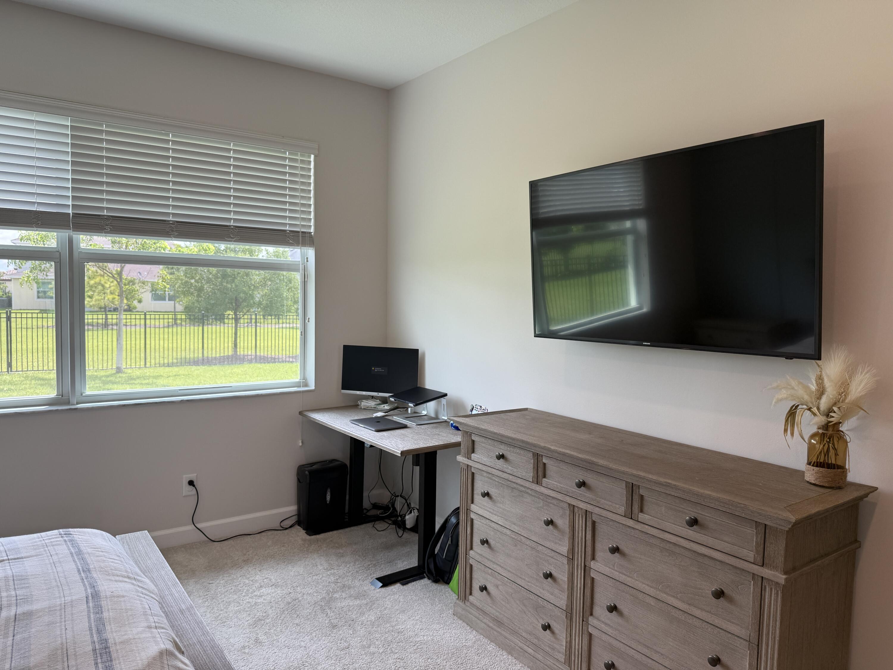 1382 Arrowhead Point Road Loxahatchee, FL 33470 - Photo 32 of 55 a bedroom with a bed and a flat screen tv