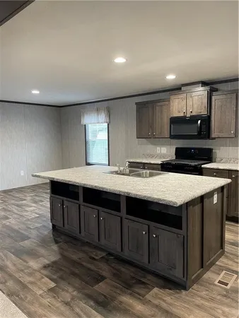 a kitchen with stainless steel appliances granite countertop a stove a sink and a microwave