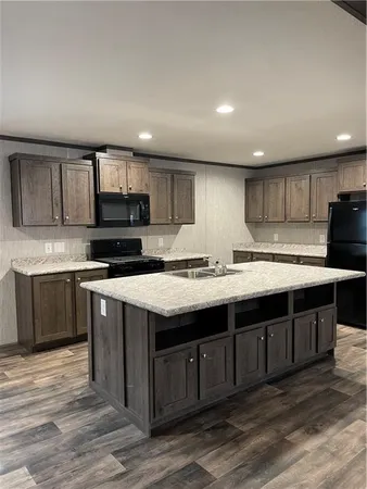 a kitchen with stainless steel appliances granite countertop a sink counter space a stove and cabinets