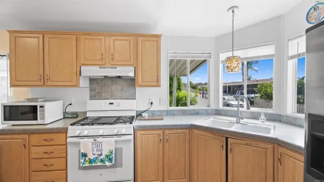 a kitchen with stainless steel appliances granite countertop a sink a stove and a microwave