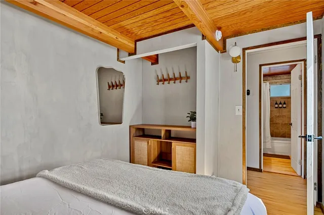 a bedroom with a bed and wooden floor