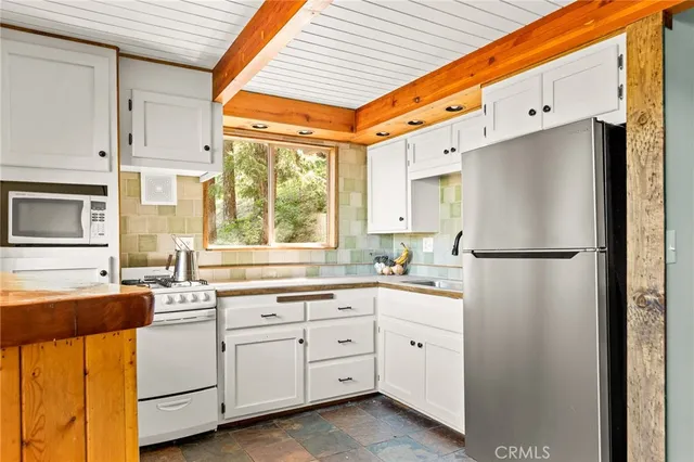 a kitchen with white cabinets and white appliances
