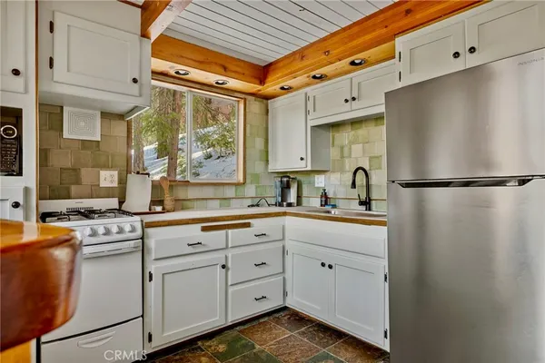 a kitchen with white cabinets and white appliances