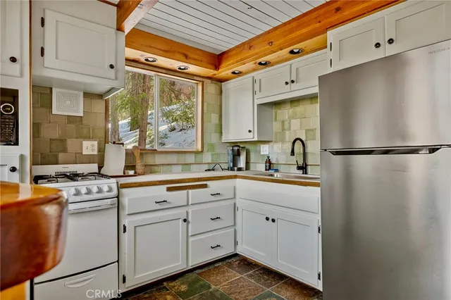 a kitchen with white cabinets and white appliances