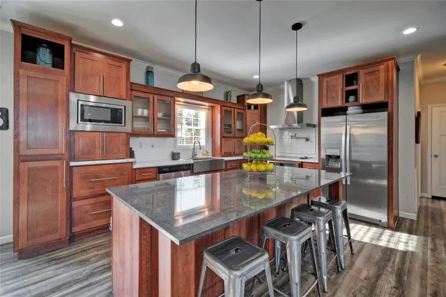 a kitchen with stainless steel appliances granite countertop a sink a oven and a refrigerator